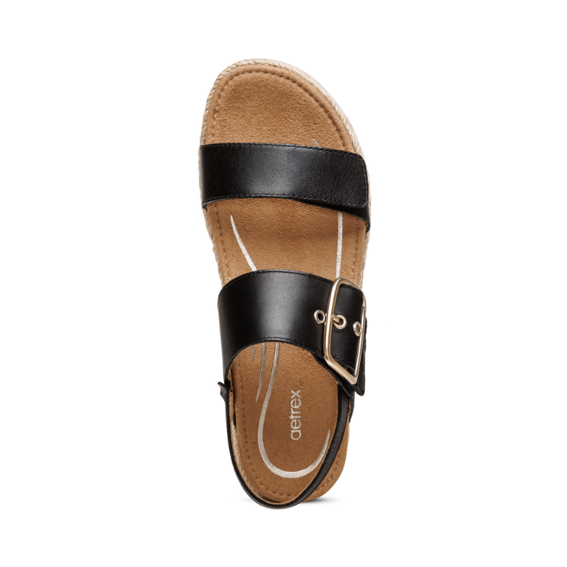 Aetrex Vania black two-strap sandal with gold buckle and tan cushioned footbed.